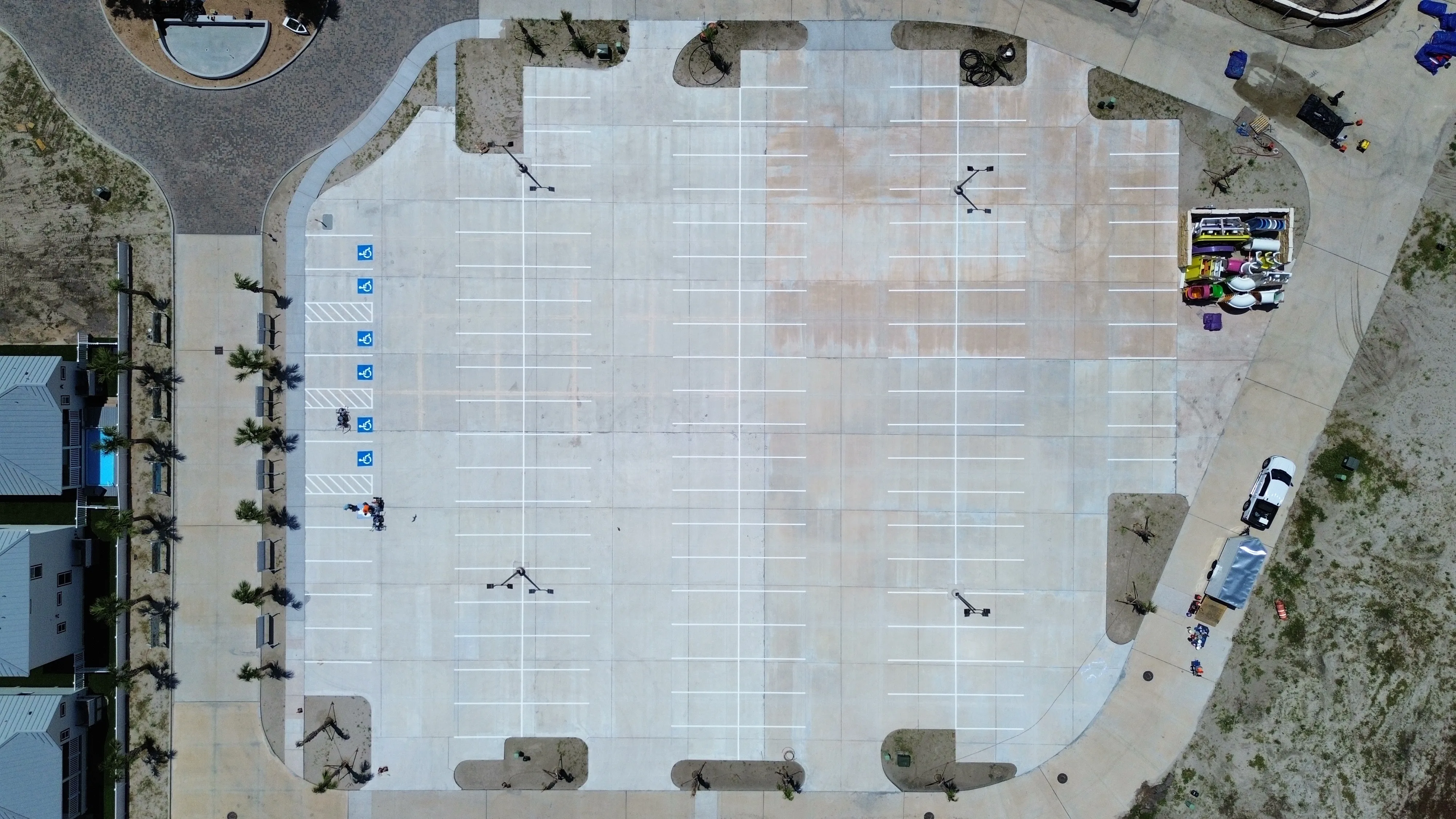 Top-down drone photo of a freshly striped coastal parking lot with accessible stalls
