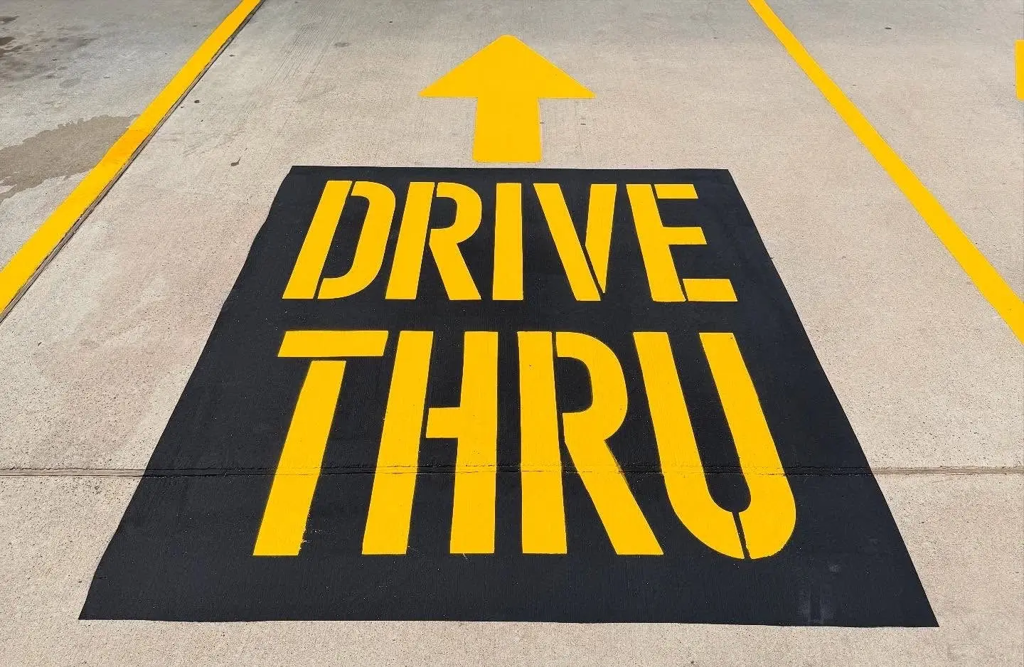 DRIVE THRU stencil and directional arrow on fresh concrete