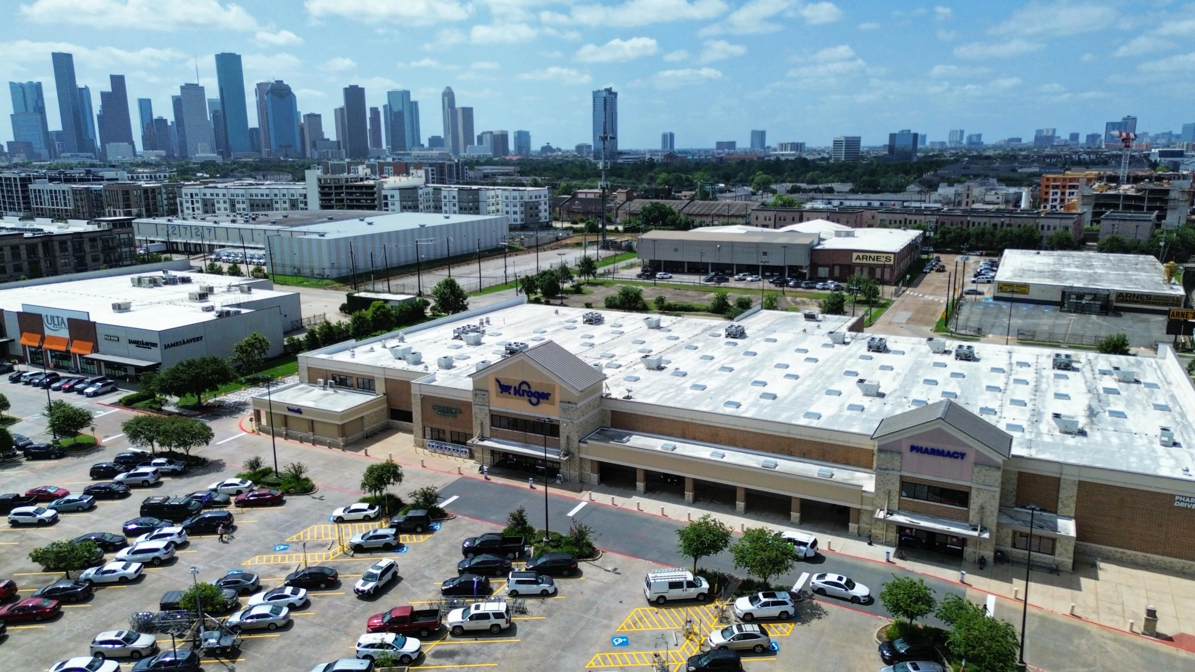 Aerial of a freshly striped retail center parking lot with the downtown Houston skyline in the distance