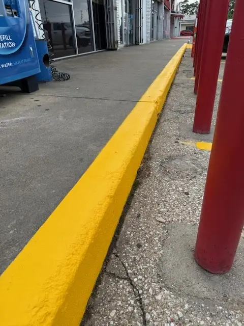 Freshly painted yellow curb along a storefront