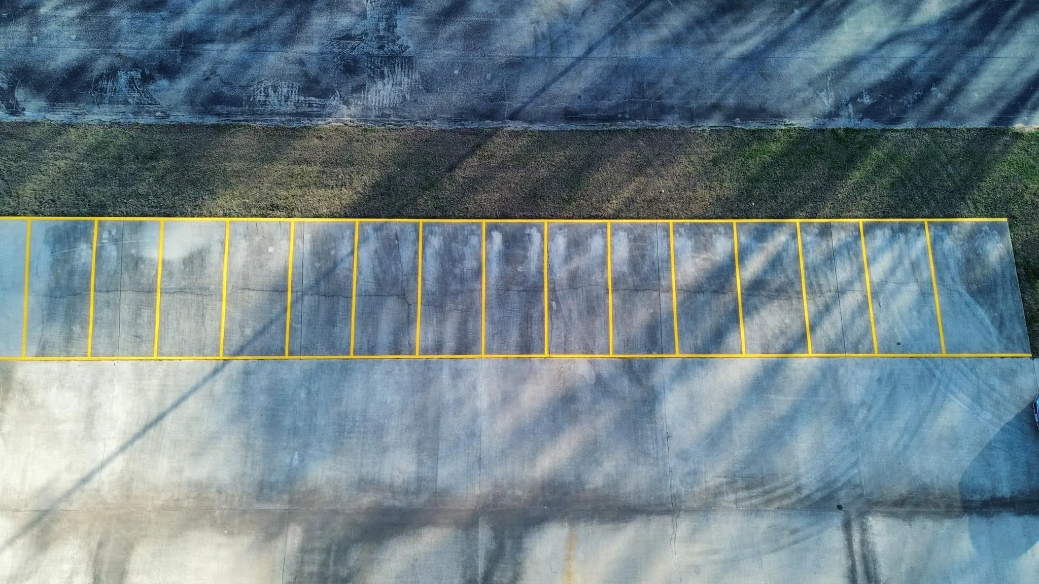 Aerial view of a long row of freshly painted yellow parking stalls
