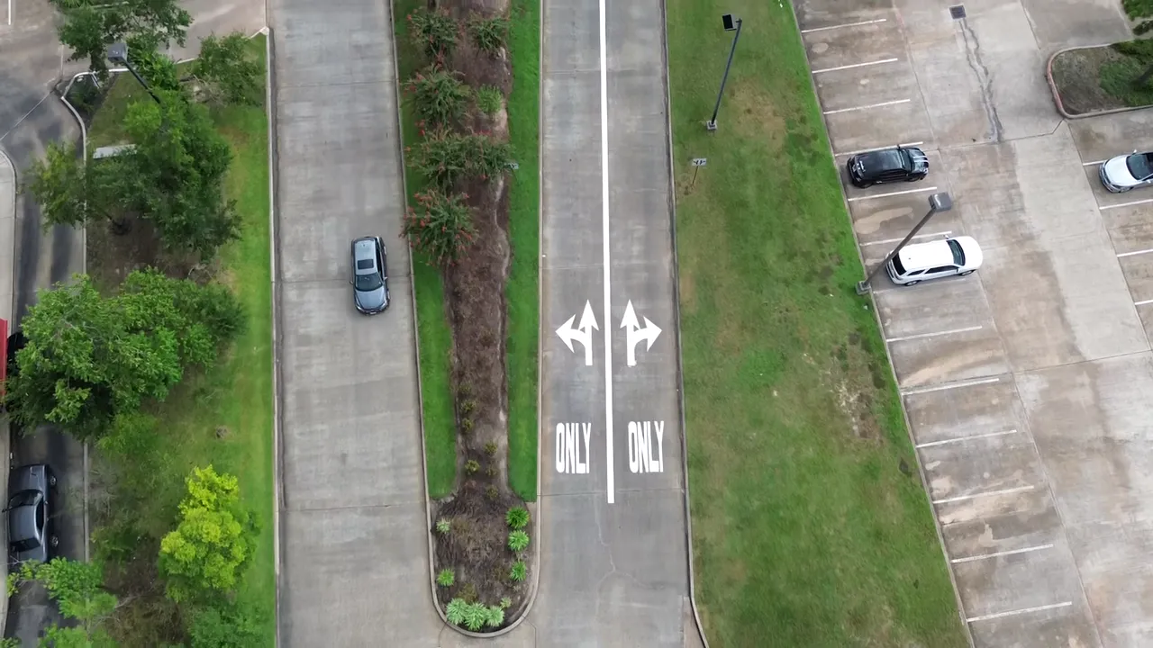 Aerial drone view of a freshly marked entrance drive with painted ONLY turn arrows