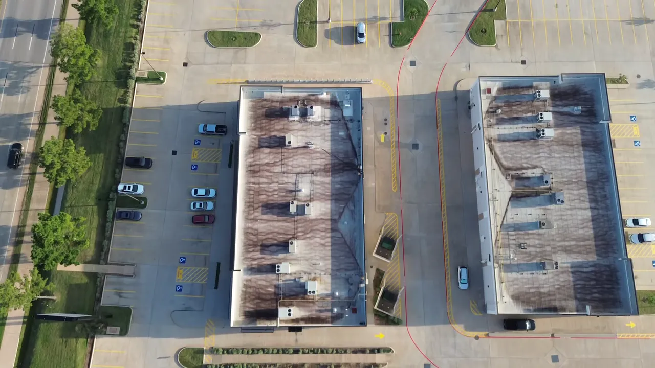 Top-down drone view of a commercial parking lot freshly striped by Coastal Roadworks