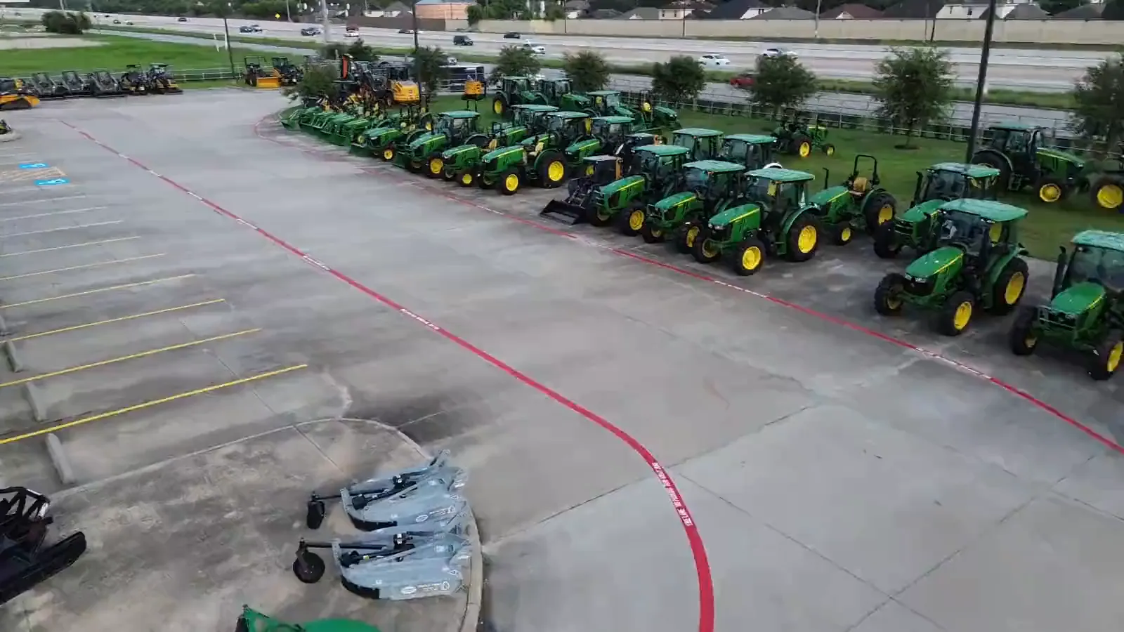 Aerial view of a freshly striped dealership lot, red fire lane and yellow accessible markings laid by Coastal Roadworks